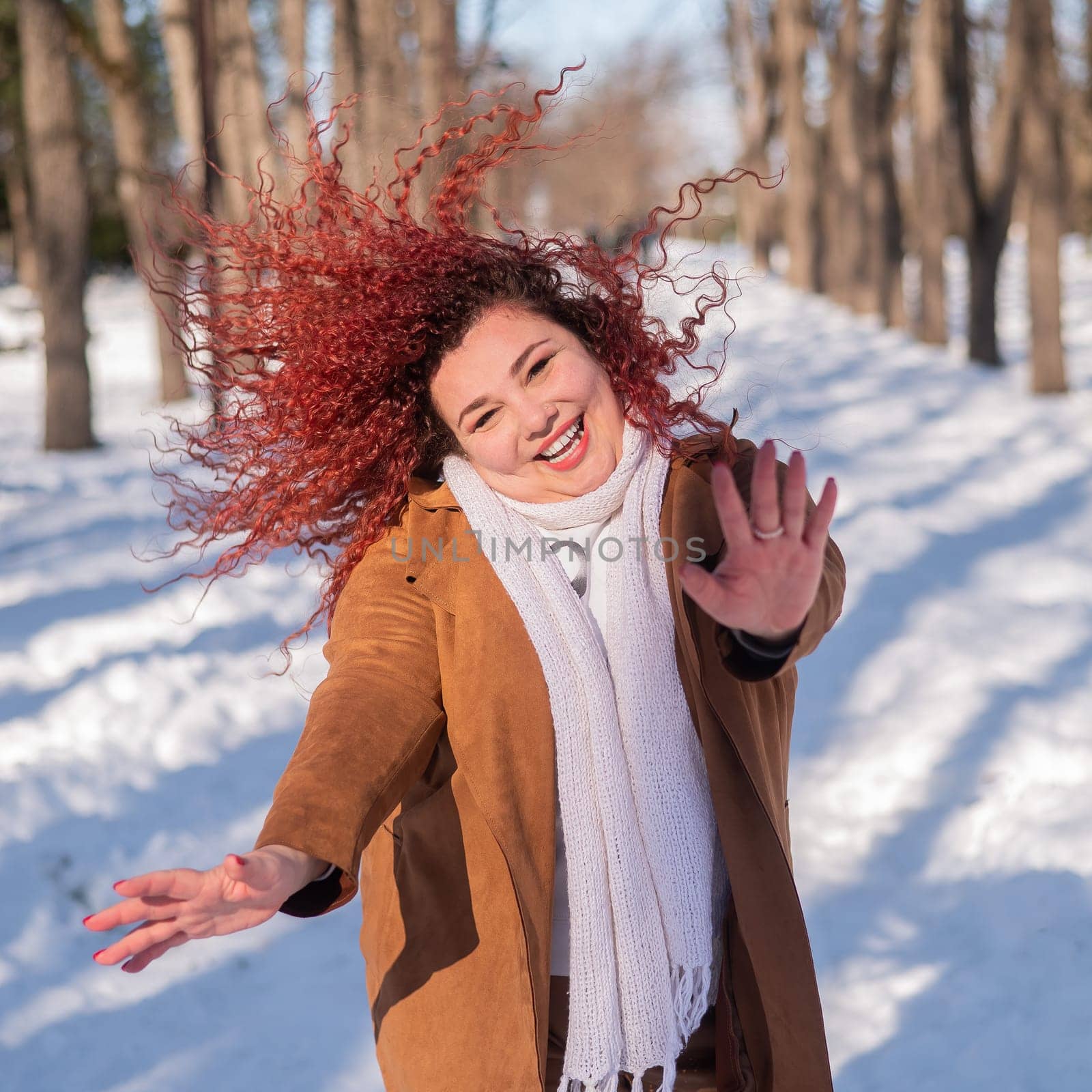 Fat caucasian woman dancing on a walk in the park in winter
