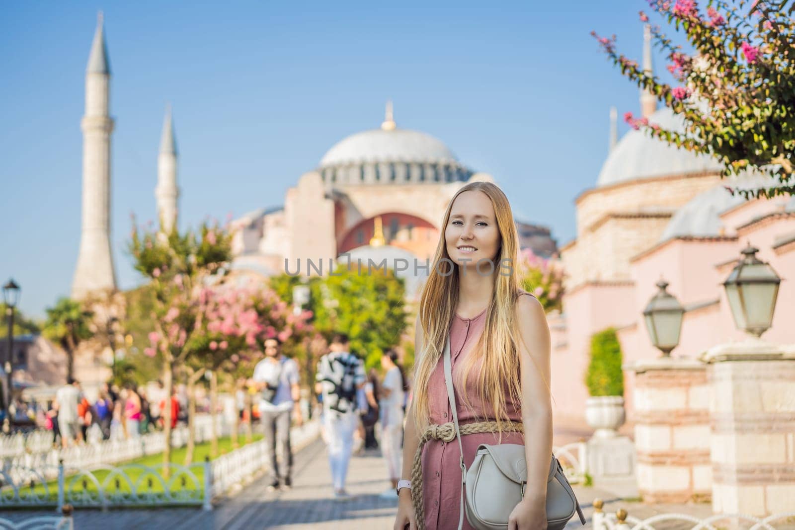 Woman enjoy beautiful view on Hagia Sophia Cathedral, famous islamic Landmark mosque, Travel to Istanbul, Turkey. Sunny day architecture and Hagia Sophia Museum, in Eminonu, istanbul, Turkey. Turkiye.
