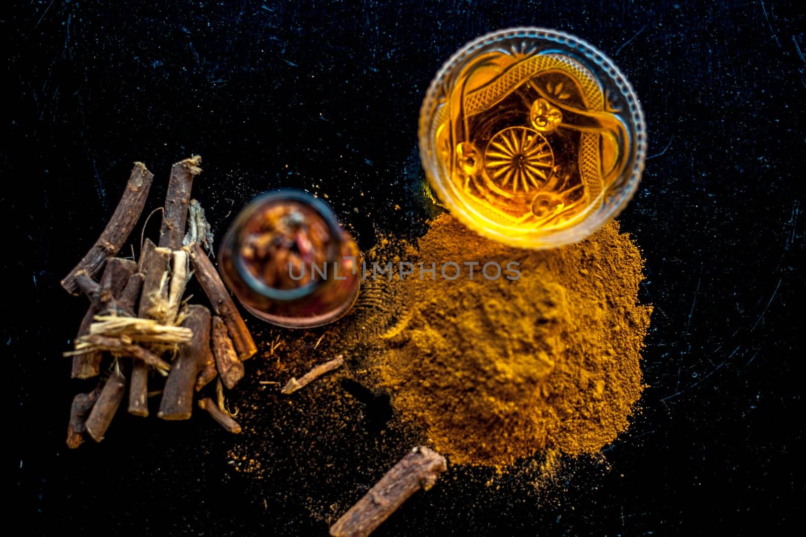 Quick Healing wound paste consisting of natural ayurvedic herbs i.e. Revand chini well mixed with rose water and honey. Shot of revand chini roots, powder, rose water and honey on a wooden surface.