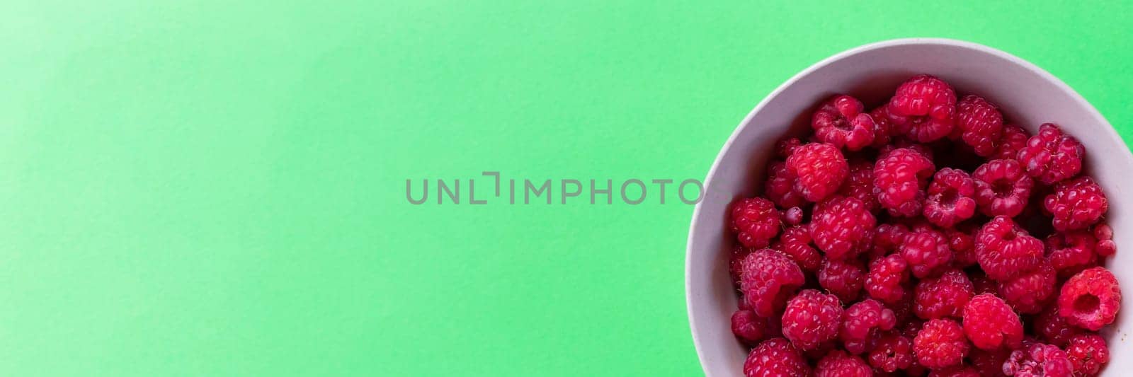 Red raspberry berry in plate on green table. Fruit berries background. Summer food.Diet vitamin and vegan food, organic, natural and healthy snack.copy space. web banner by YuliaYaspe1979