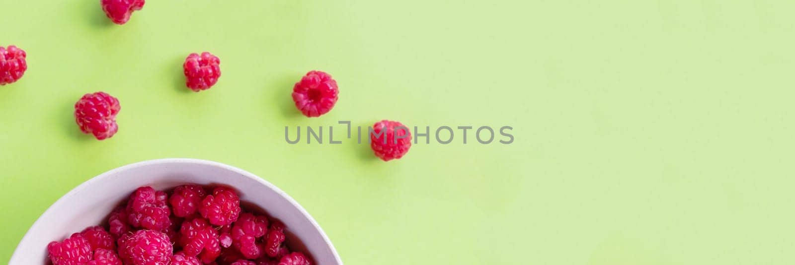 Red raspberry berry in plate on green table. Fruit berries background. Summer food.Diet vitamin and vegan food, organic, natural and healthy snack.copy space. web banner by YuliaYaspe1979
