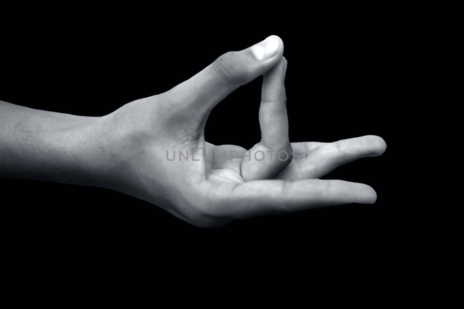 Shot of a male hand demonstrating Aakash Mudra isolated on black background. by mirzamlk