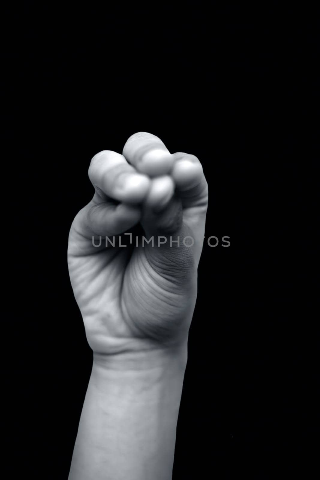 Shot of male hands doing Mukula mudra isolated on black background. Vertical shot. by mirzamlk