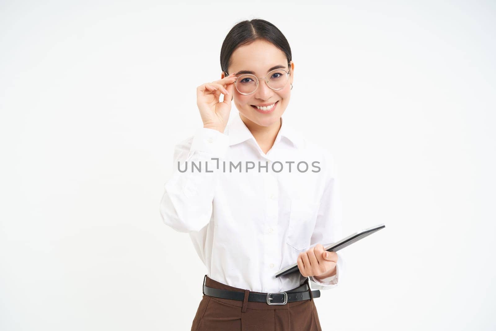 Asian woman professional, businesswoman in glasses, holding digital tablet, standing confident against white background.