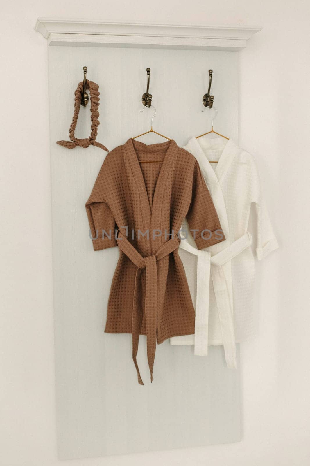 Linen bathrobes hang on a hanger in the bathroom by Sd28DimoN_1976