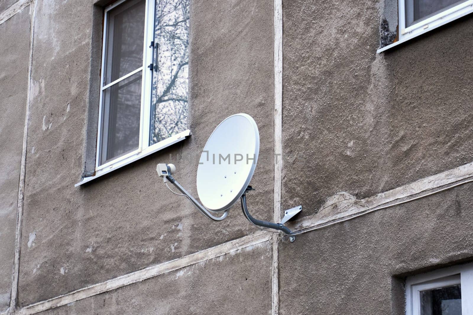 Satellite TV dish on the wall of a house