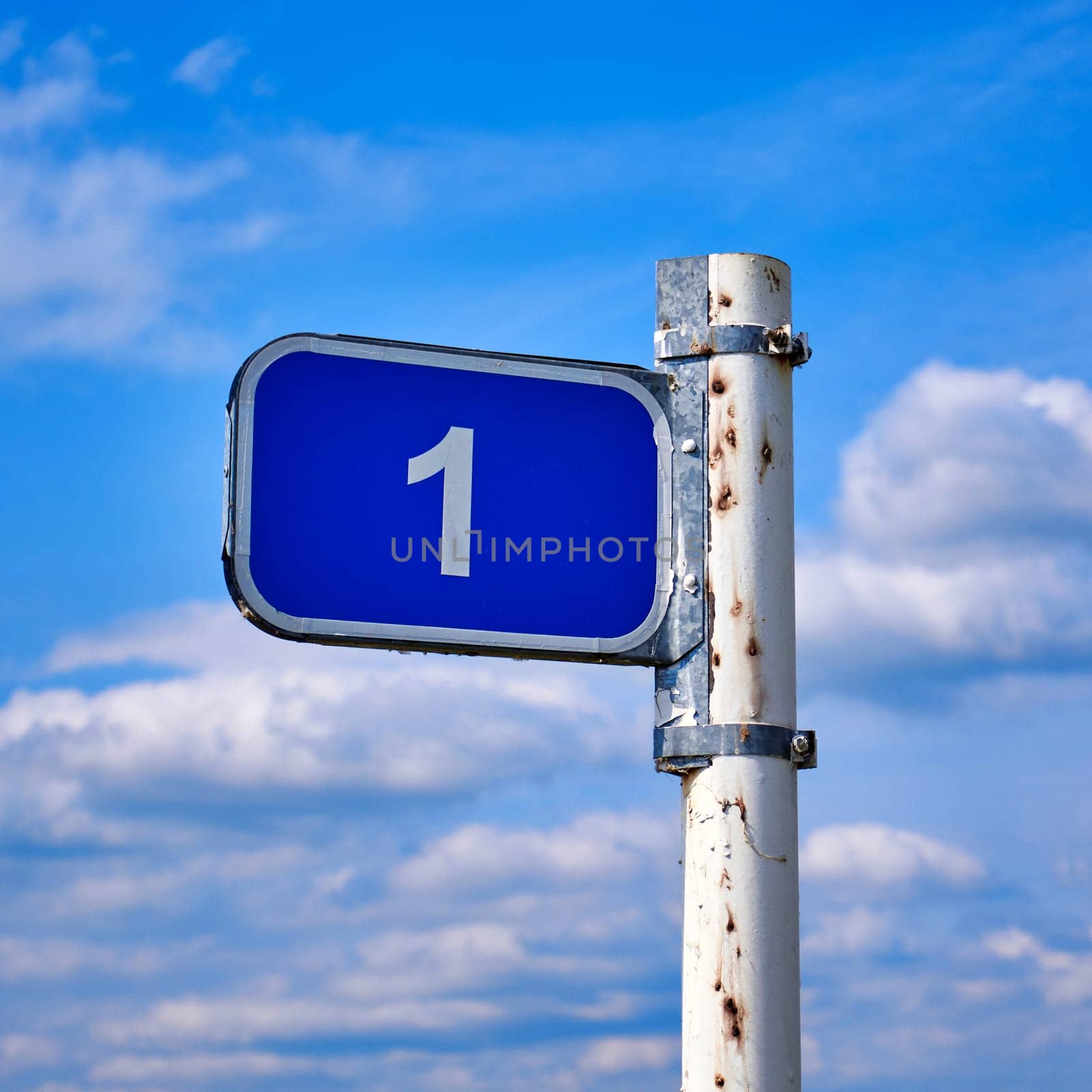 Road sign one kilometer against the blue sky