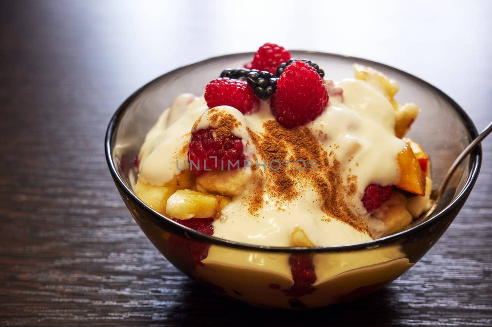 Fresh delicious fruit salad with yogurt on a wooden table