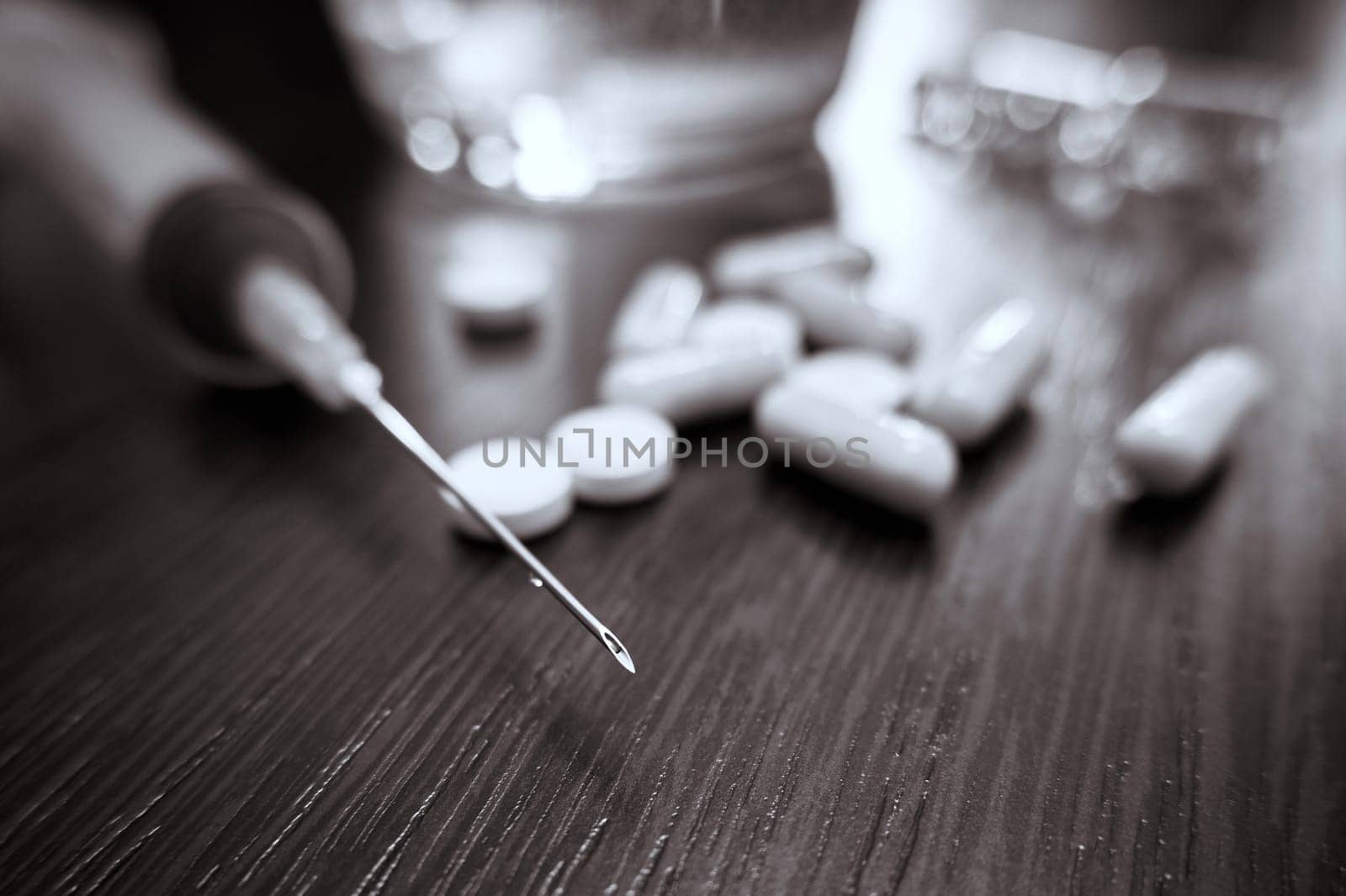 Medical syringe and pills on the table close-up. Selective focus