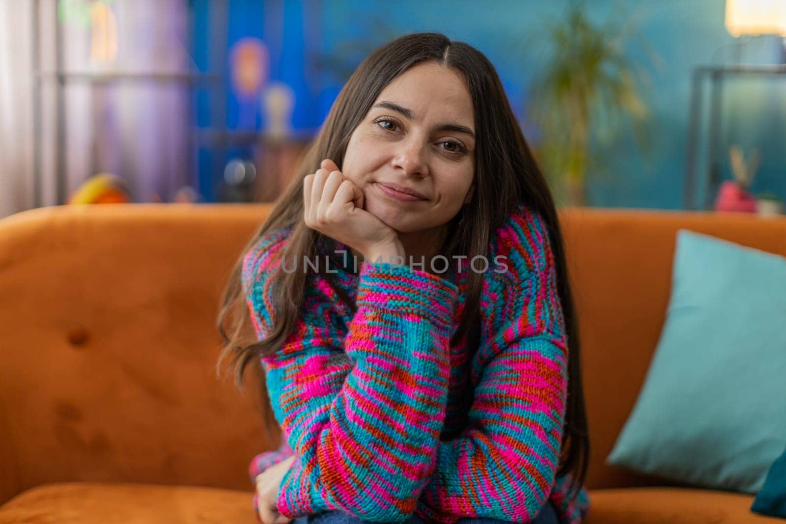 Portrait of happy calm Caucasian woman at home couch smiling friendly, glad expression looking away dreaming resting, relaxation feel satisfied concept good news, celebrate win. Young girl in room
