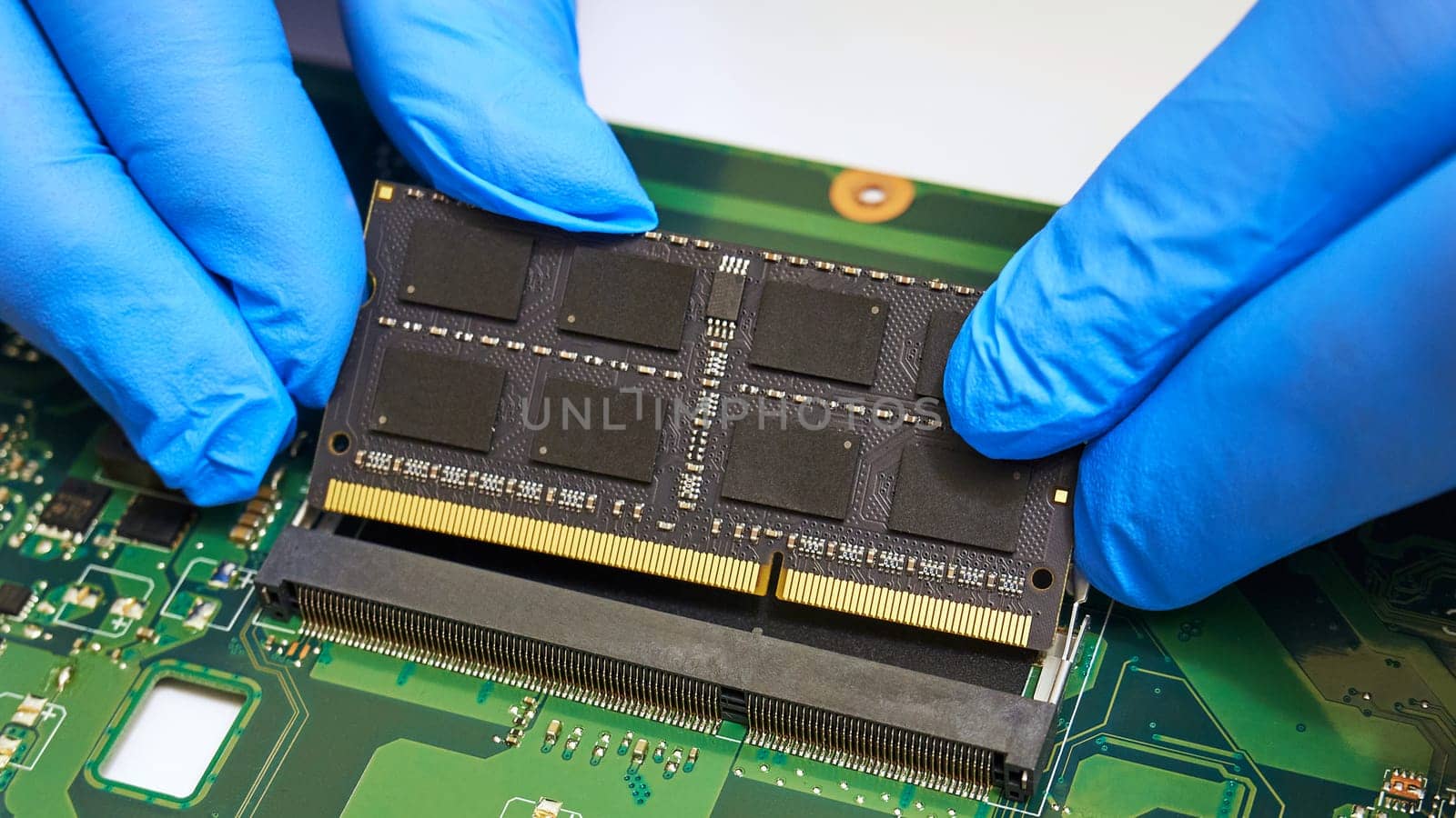 Installing a RAM module on a laptop motherboard close-up