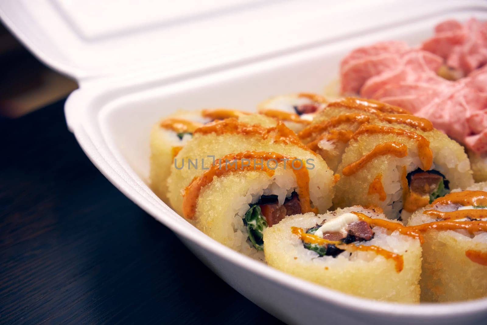 Sushi rolls in a white plastic container. Food delivery