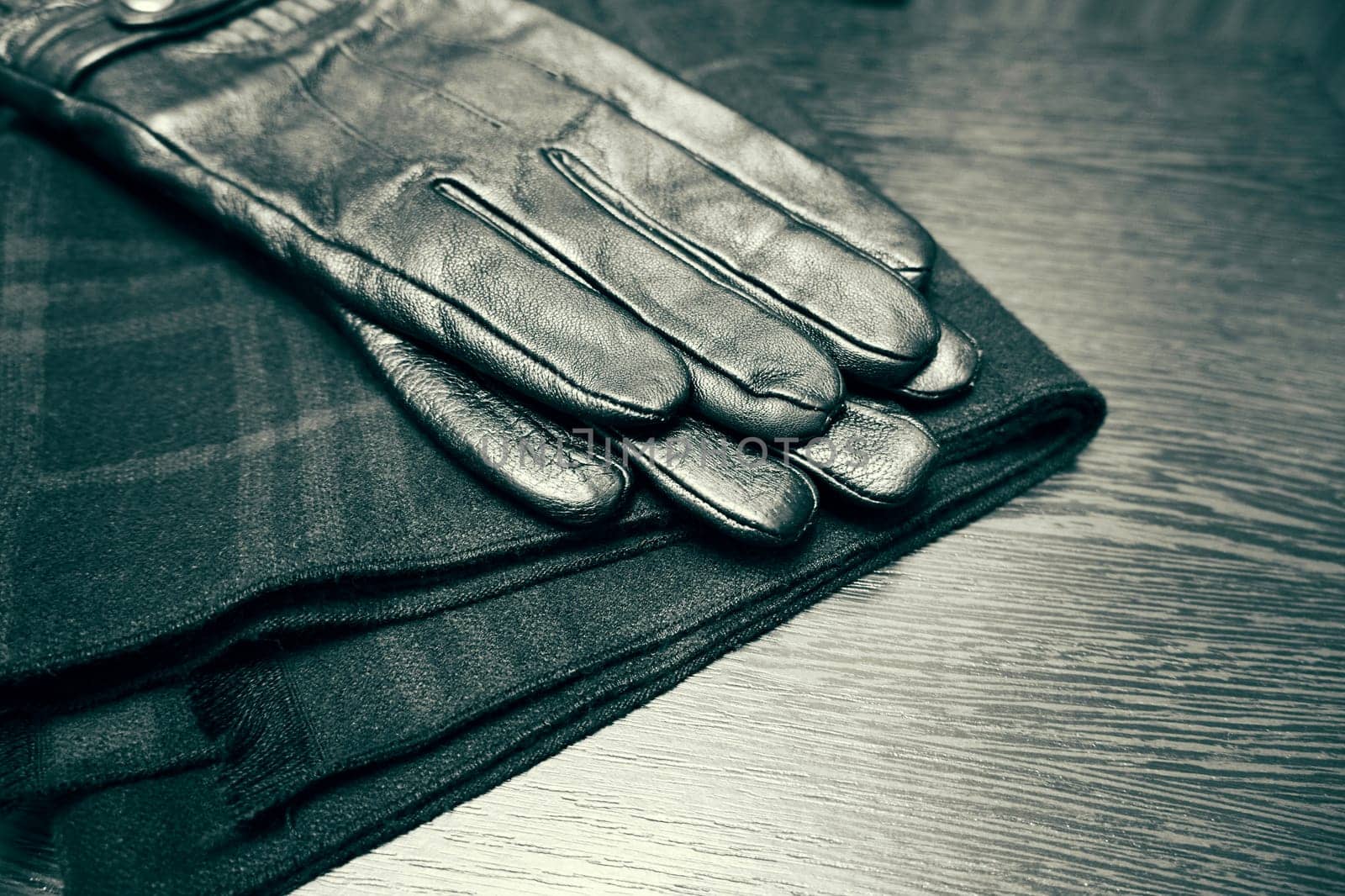 Men's leather gloves and checkered scarf. Selective focus