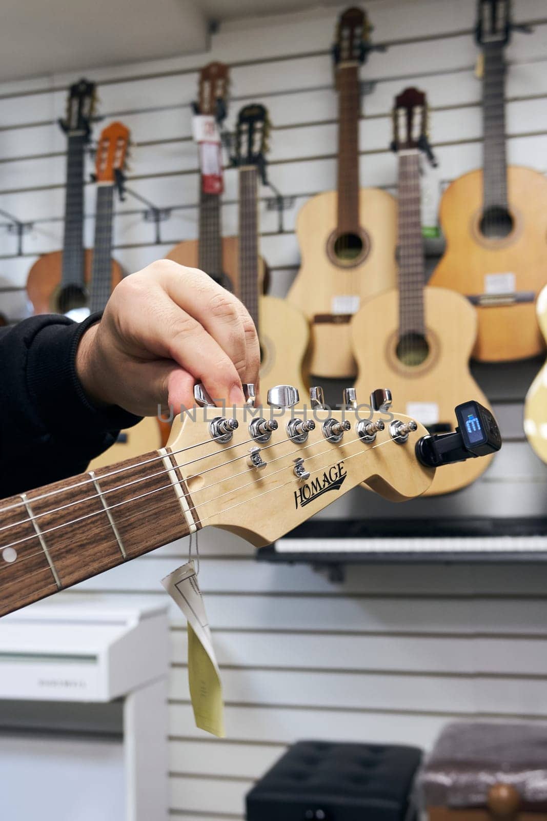 Ryazan, Russia - October 9, 2022: Guitar tuning before selling in a music store