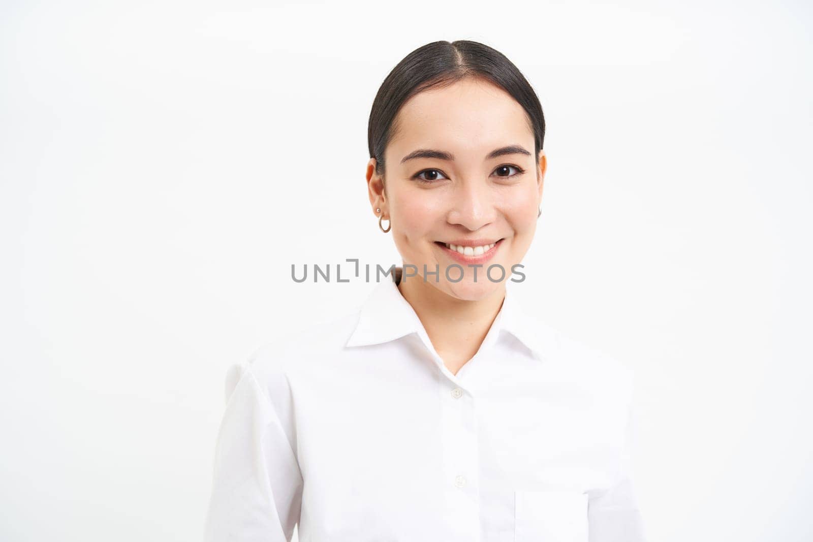 Portrait of korean businesswoman in shirt, smiles at camera, concept of corporate people and business, stands over white background.