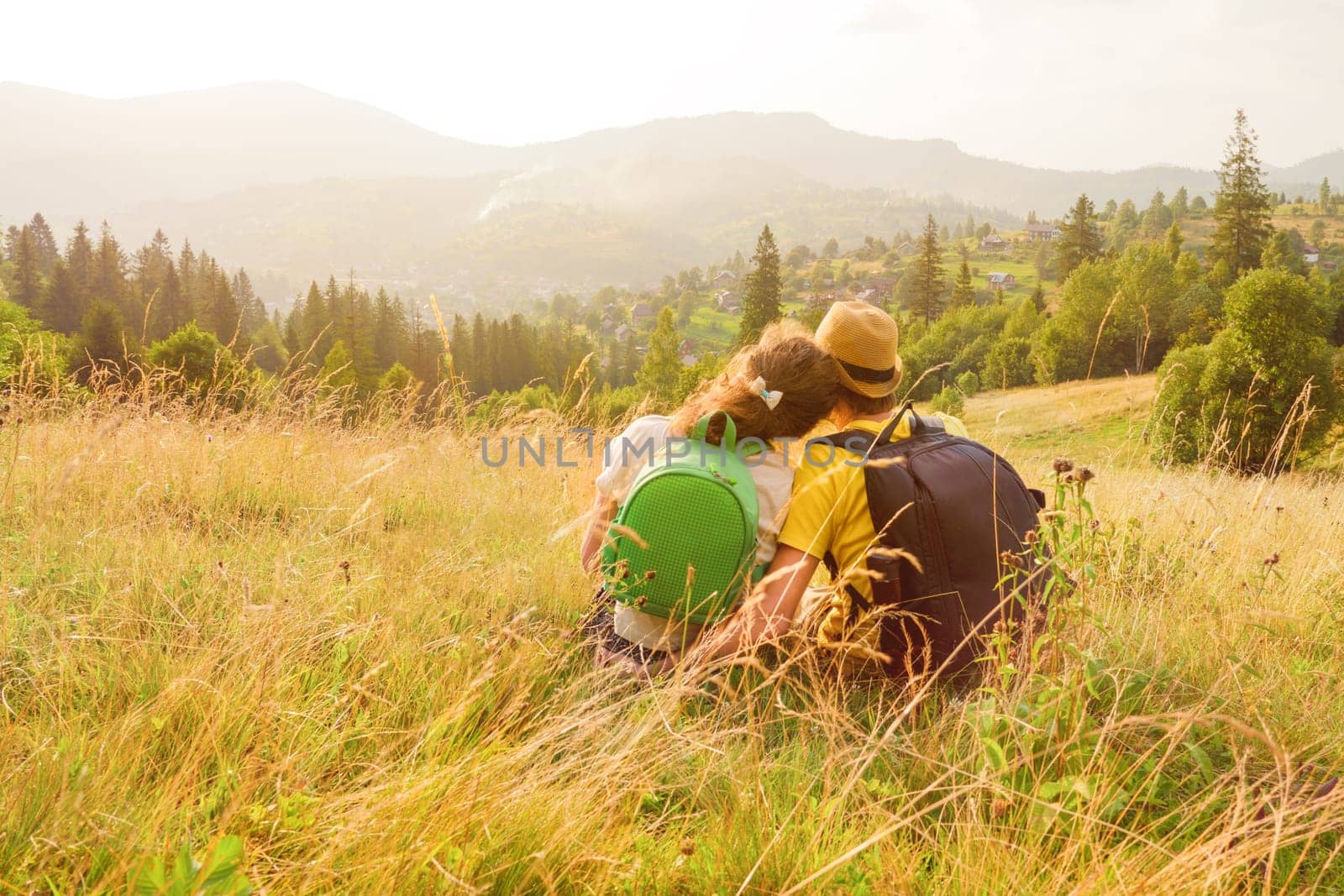 Happy young couple sitting on mountain couple looking at view mountain love couple nature vacation green travel love vacation summer mountain travel rest people nature travel love together. Back view