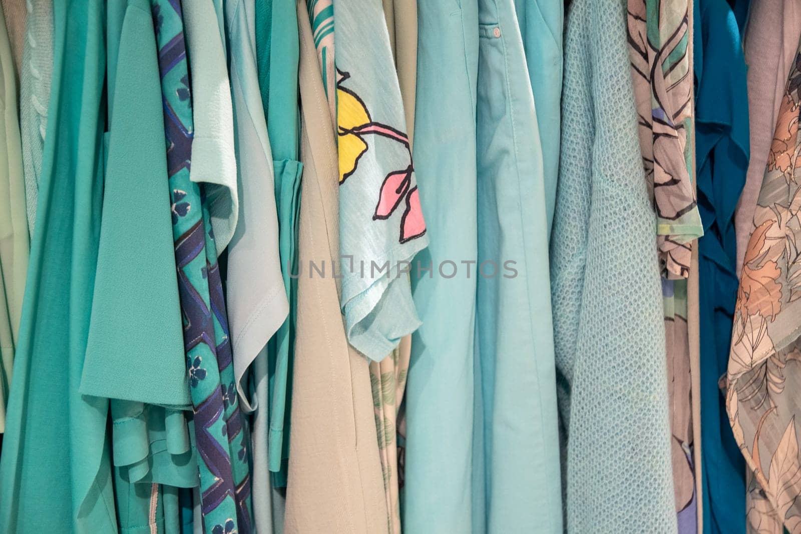 different models blue beige blouses in second hand store on a hanger, bright summer colors of fashion clothes, High quality photo