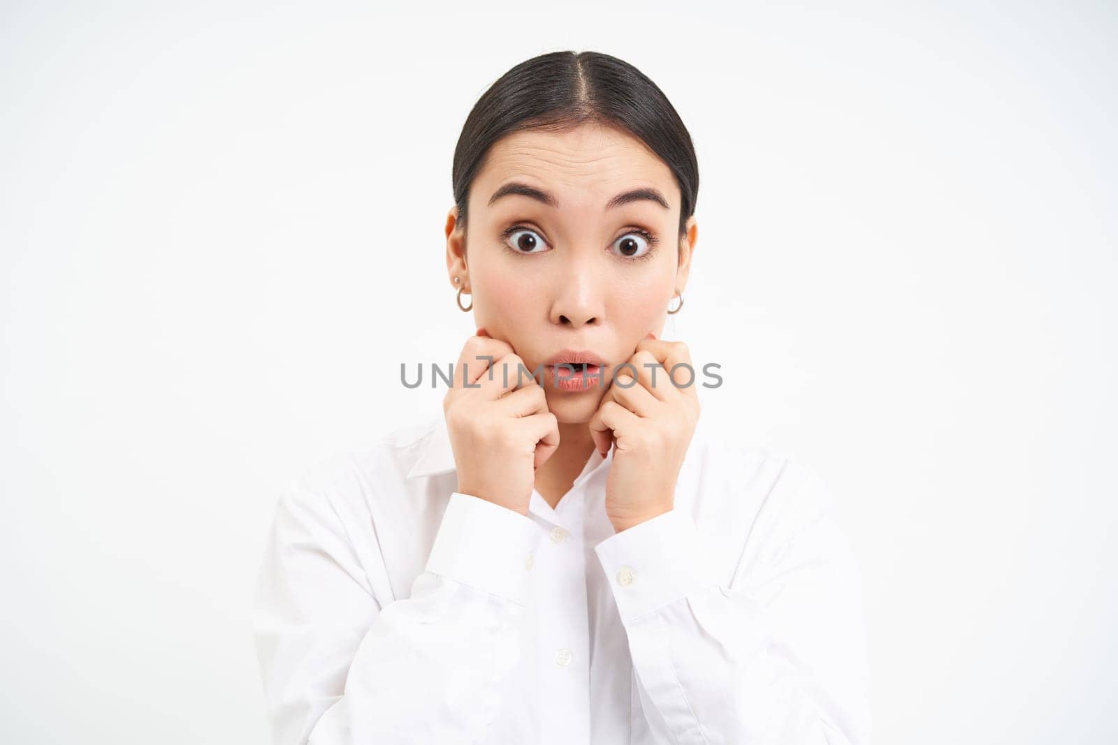 Portrait of asian businesswoman looks surprised, amazed reaction on advertisement, stands over white background.