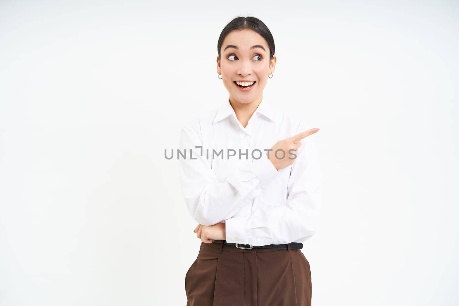 Image of asian businesswoman points finger to the right, shows advertisement, demonstrates banner, white background.