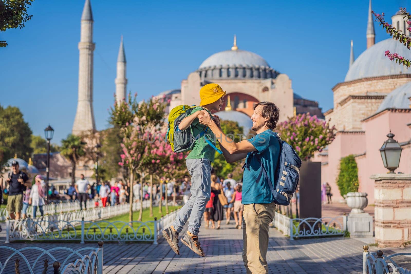 Father and son Tourists enjoy beautiful view on Hagia Sophia Cathedral, famous islamic Landmark mosque, Travel to Istanbul, Turkey. Traveling with kids concept. Sunny day architecture and Hagia Sophia Museum, in Eminonu, istanbul, Turkey. Turkiye.