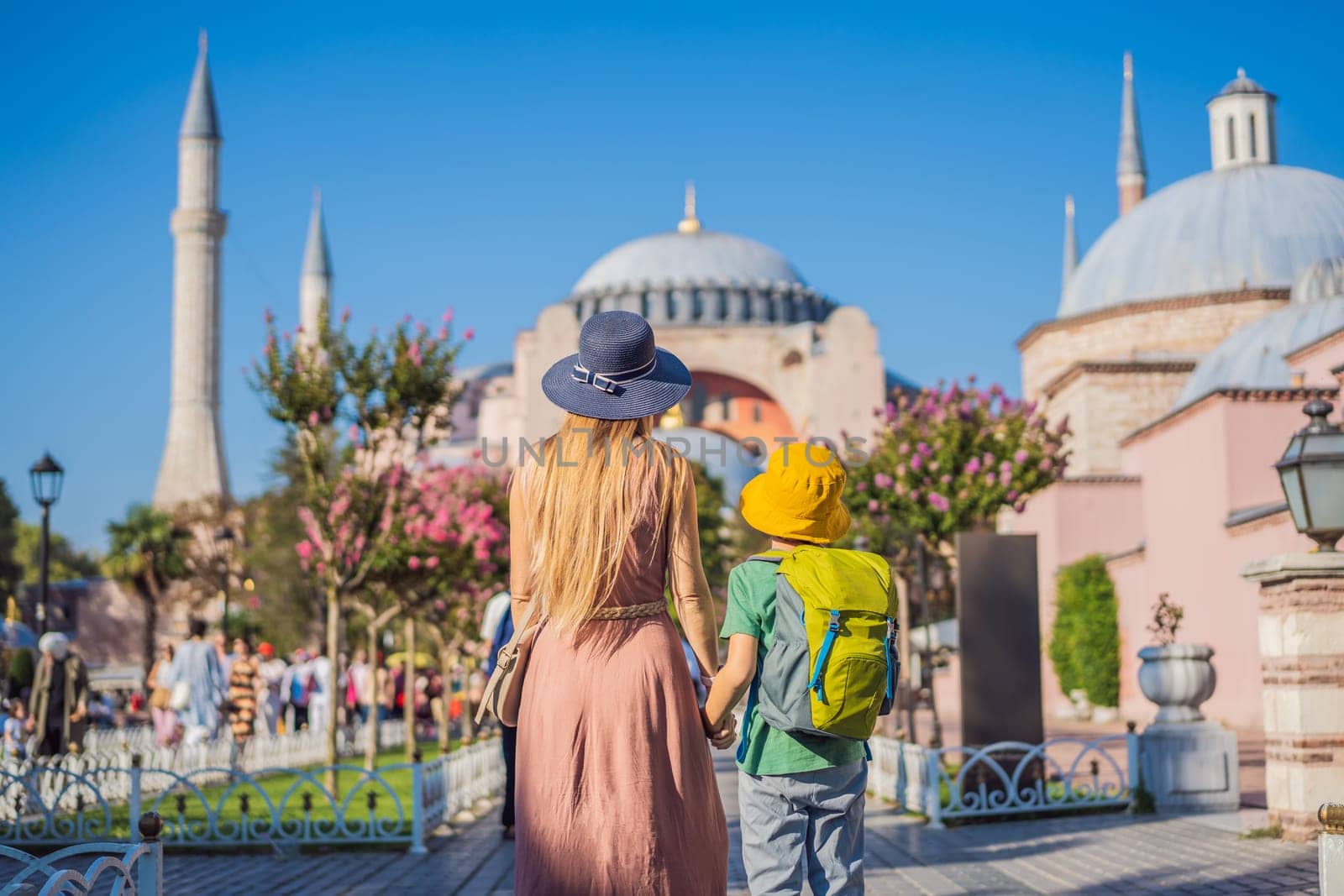 Mother and son Tourists enjoy beautiful view on Hagia Sophia Cathedral, famous islamic Landmark mosque, Travel to Istanbul, Turkey. Traveling with kids concept. Sunny day architecture and Hagia Sophia Museum, in Eminonu, istanbul, Turkey. Turkiye.