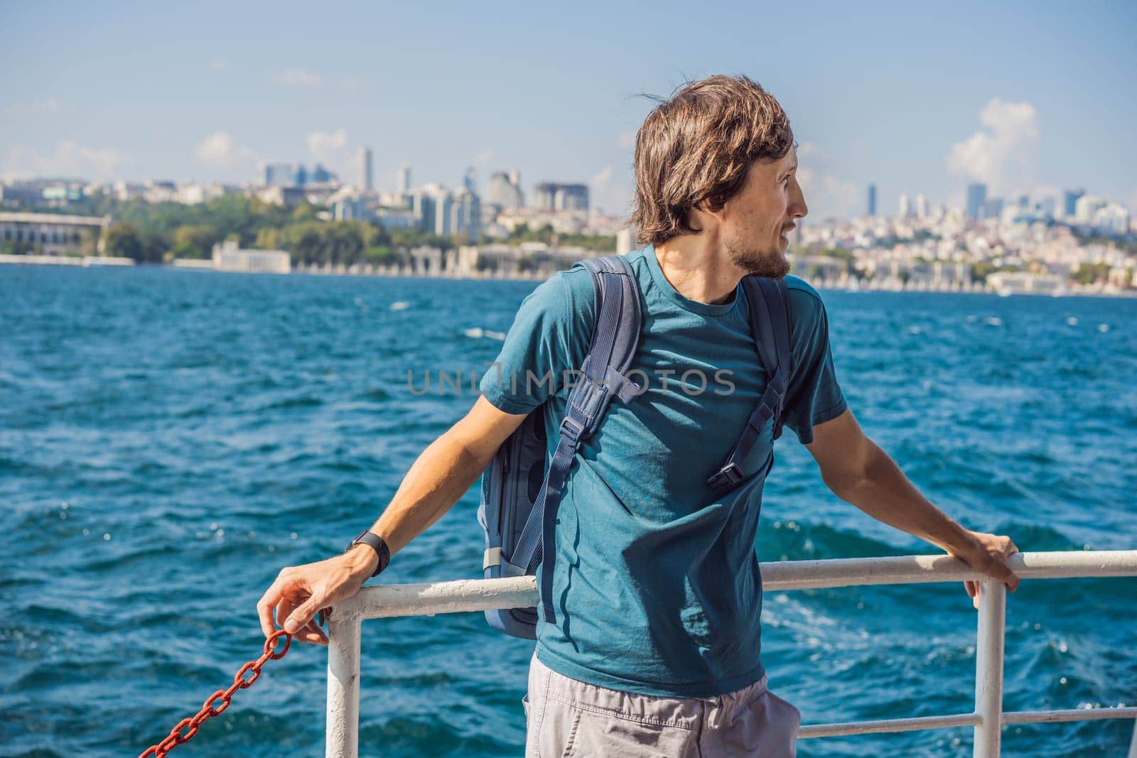 Happy man enjoying the sea from ferry boat crossing Bosphorus in Istanbul. Summer trip to Istanbul.