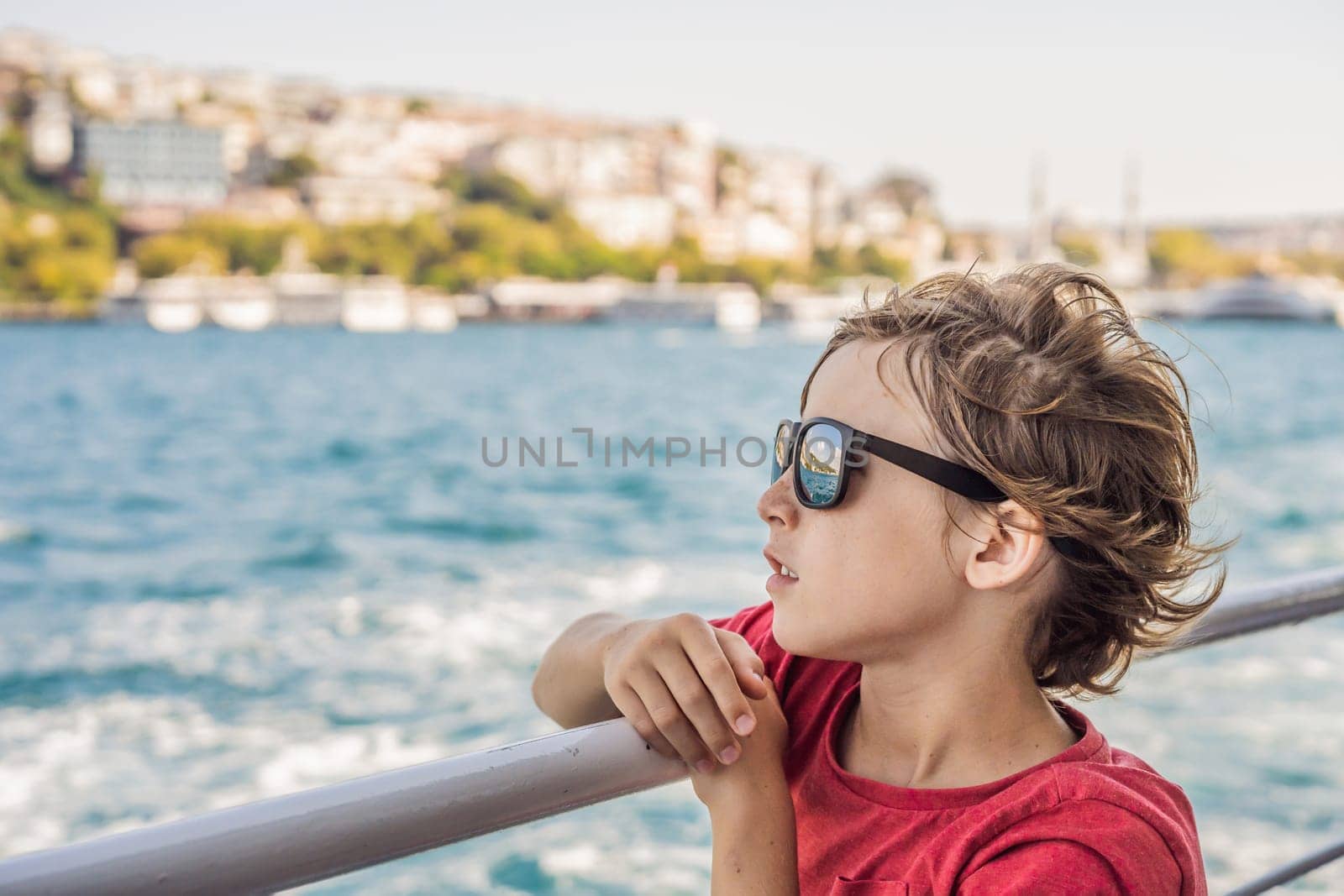 Happy boy enjoying the sea from ferry boat crossing Bosphorus in Istanbul. Summer trip to Istanbul. Traveling with kids concept.