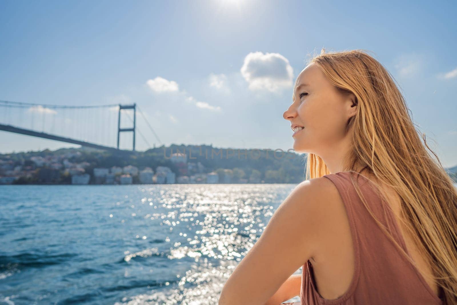 Happy woman enjoying the sea from ferry boat crossing Bosphorus in Istanbul. Summer trip to Istanbul.
