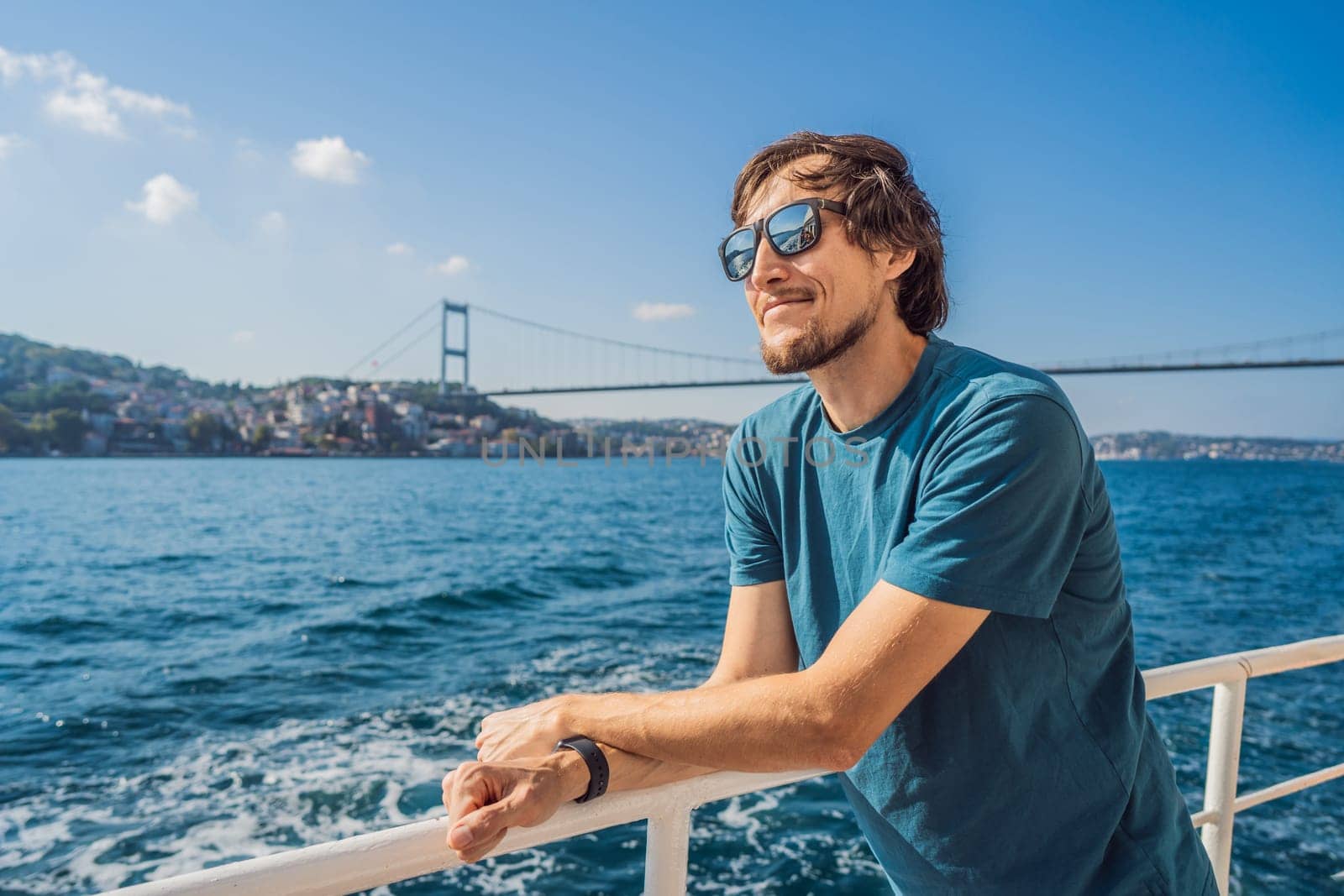 Happy man enjoying the sea from ferry boat crossing Bosphorus in Istanbul. Summer trip to Istanbul.