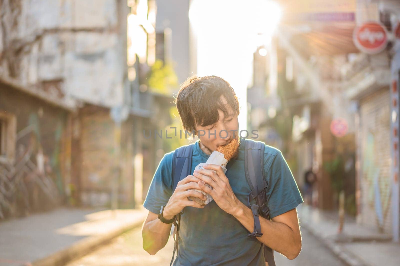 Man eating street food in Istanbul. Balik ekmek - fish in a bread, traditional Turkish fast food. Istanbul, Turkey.