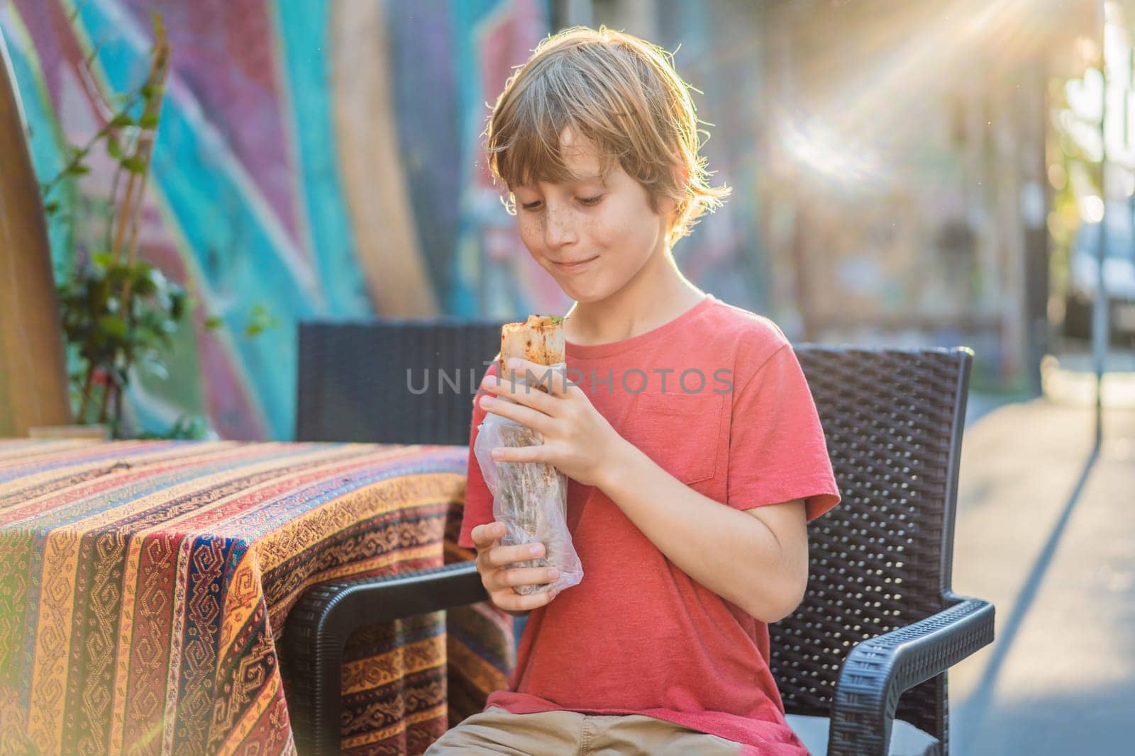 Boy eating street food in Istanbul. Balik ekmek - fish in a bread, traditional Turkish fast food. Istanbul, Turkey.