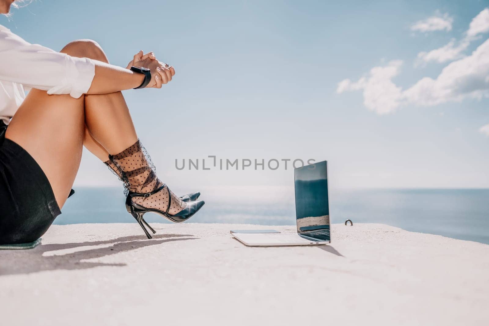 Happy girl doing yoga with laptop working at the beach. beautiful and calm business woman sitting with a laptop in a summer cafe in the lotus position meditating and relaxing. freelance girl remote work beach paradise