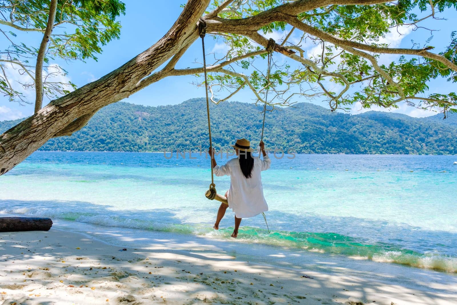 woman at a rope swing on the beach of Koh Lipe Island Southern Thailand by fokkebok