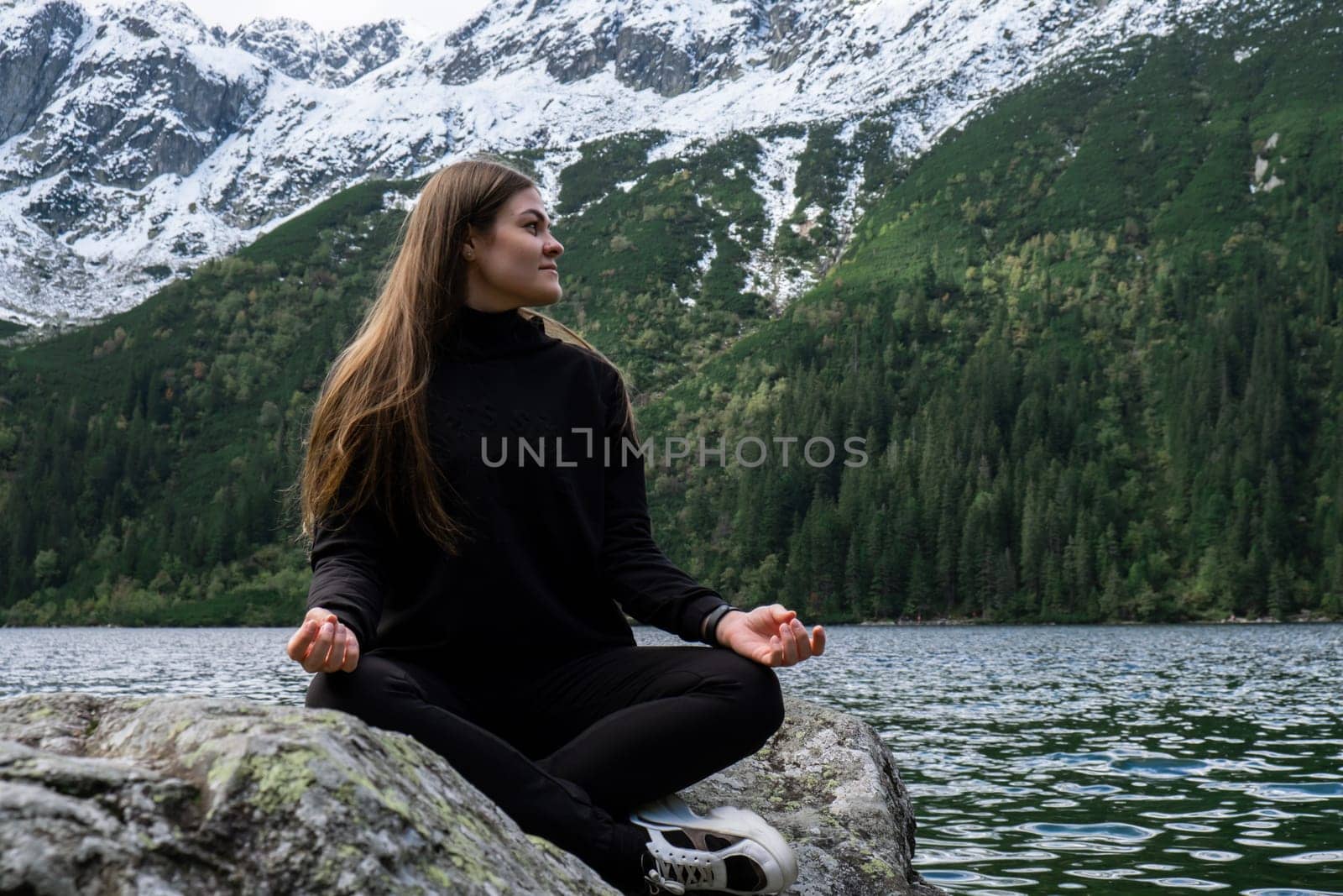 Young woman enjoying nature in Morskie Oko Snowy Mountain Hut in Polish Tatry mountains Zakopane Poland. Naturecore aesthetic beautiful green hills. Mental and physical wellbeing Travel outdoors tourist destination