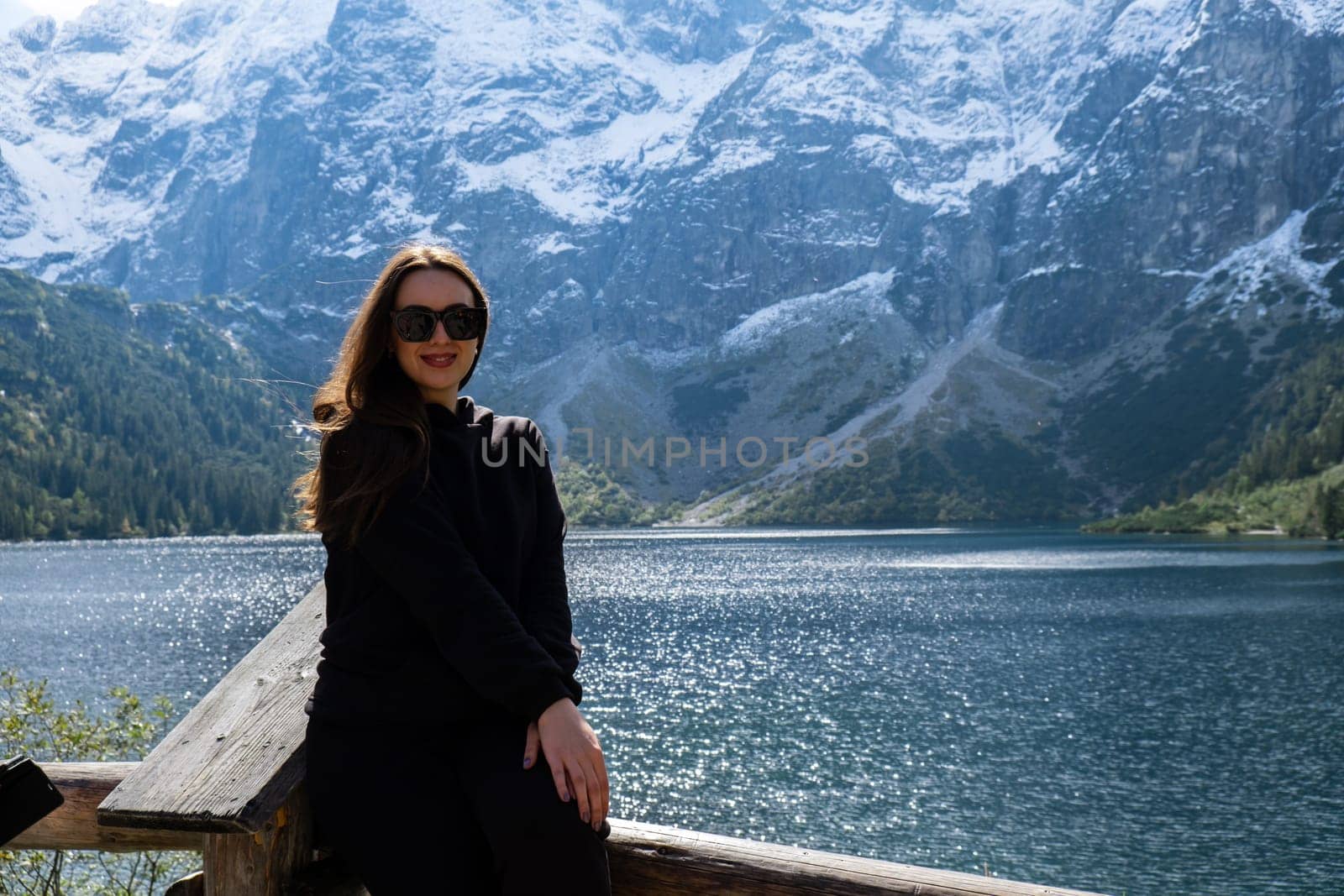 Young woman enjoying nature in Morskie Oko Snowy Mountain Hut in Polish Tatry mountains Zakopane Poland. Naturecore aesthetic beautiful green hills. Mental and physical wellbeing Travel outdoors tourist destination