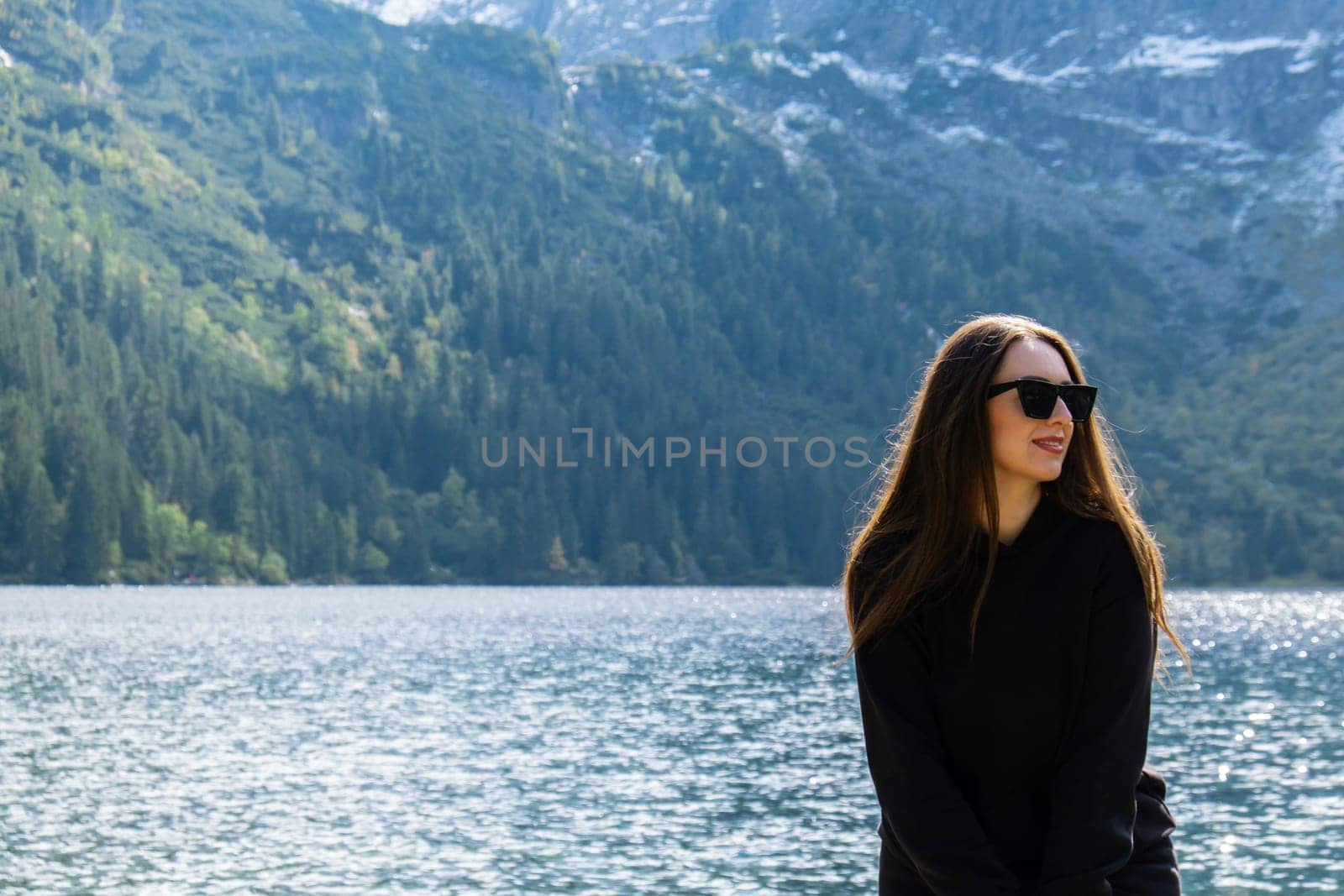 Young woman enjoying nature in Morskie Oko Snowy Mountain Hut in Polish Tatry mountains Zakopane Poland. Naturecore aesthetic beautiful green hills. Mental and physical wellbeing Travel outdoors tourist destination
