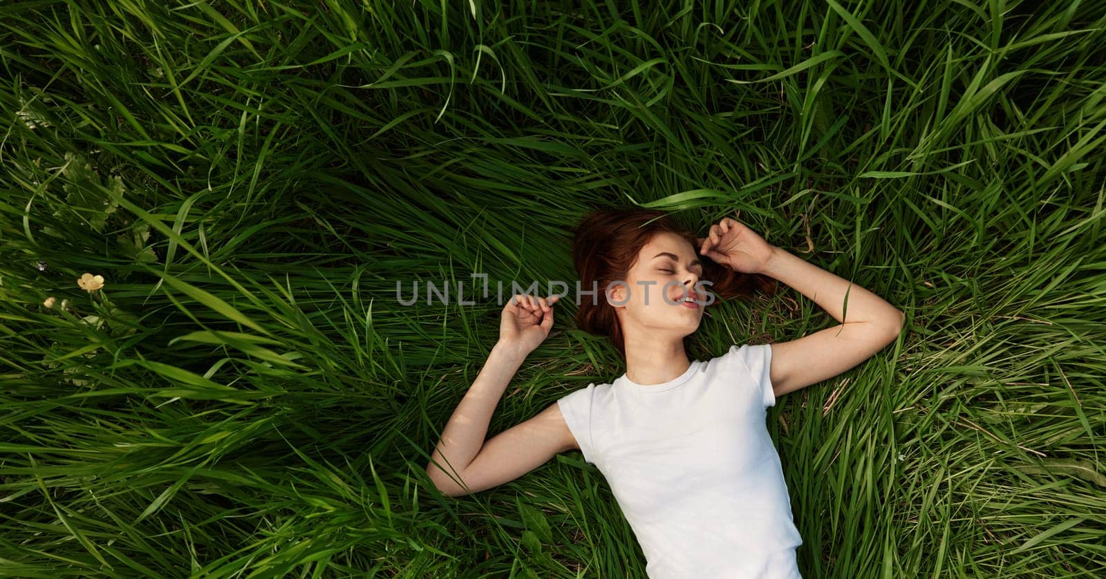 happy woman lies in green grass field. High quality photo