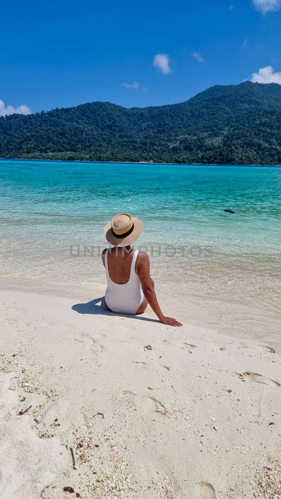 Koh Lipe Island Southern Thailand with turqouse colored ocean and white sandy beach at Ko Lipe. a women on vacation in Thailand walking at the beach