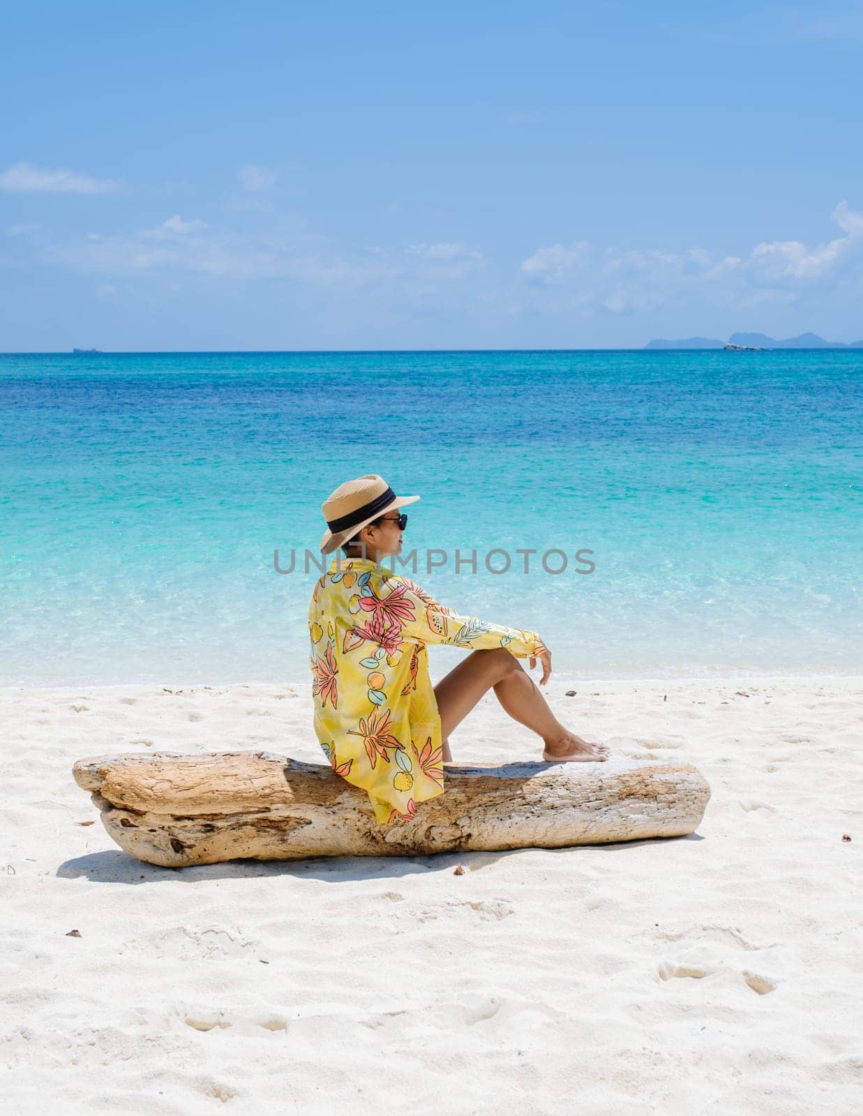Koh Lipe Island Southern Thailand with turqouse colored ocean and white sandy beach at Ko Lipe. a Asian women on vacation in Thailand walking at the beach