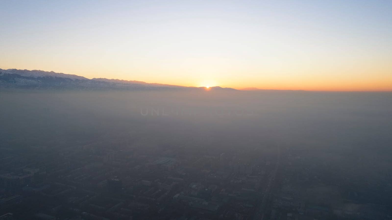 Epic gray smog is visible at sunset over the city by Passcal