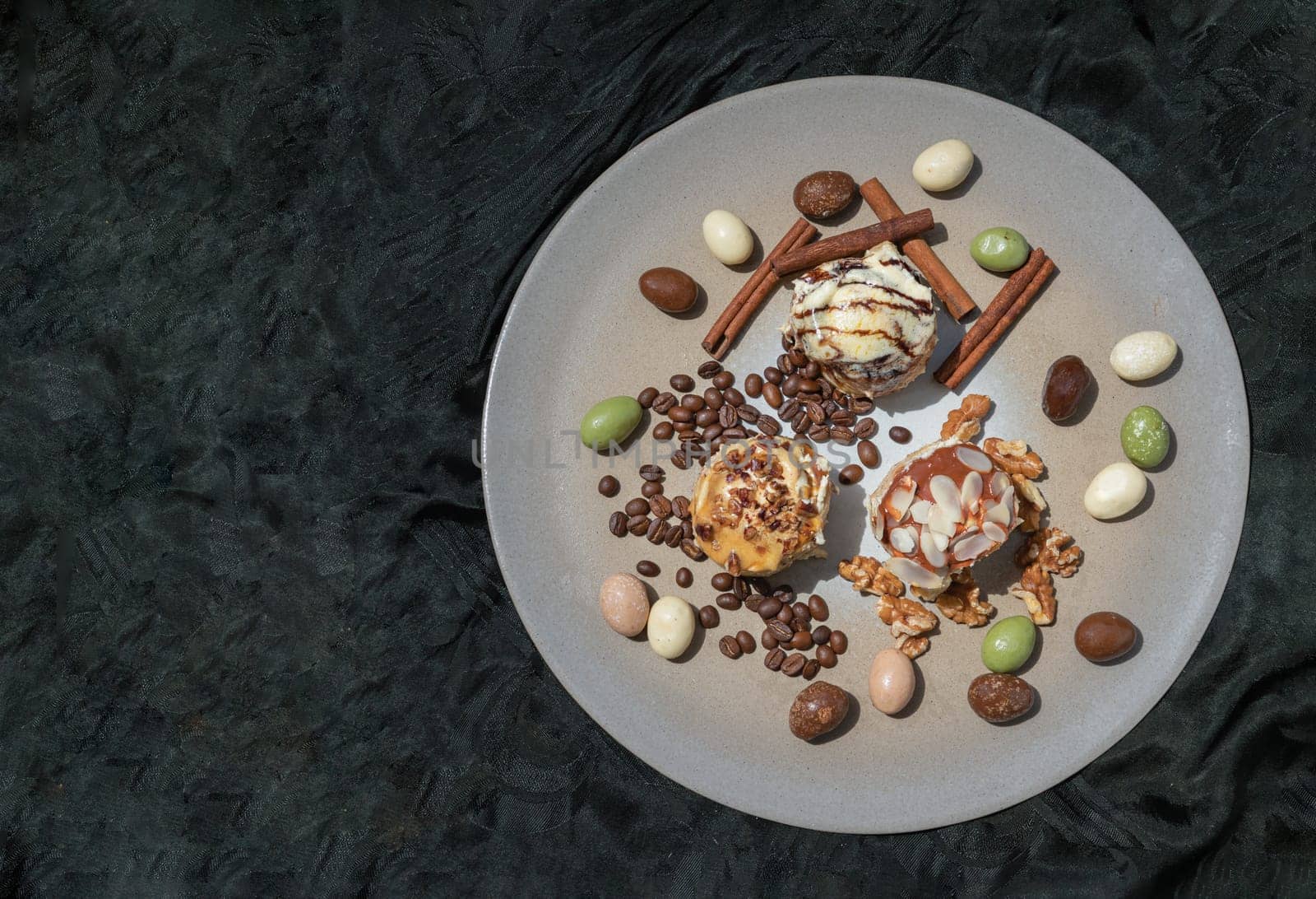 Bakery, Stick cookies, Walnuts, Colored eggs, Roasted coffee beans and Cinnamon on Ceramic tray with dark background. Space for text, Top view, Selective focus.