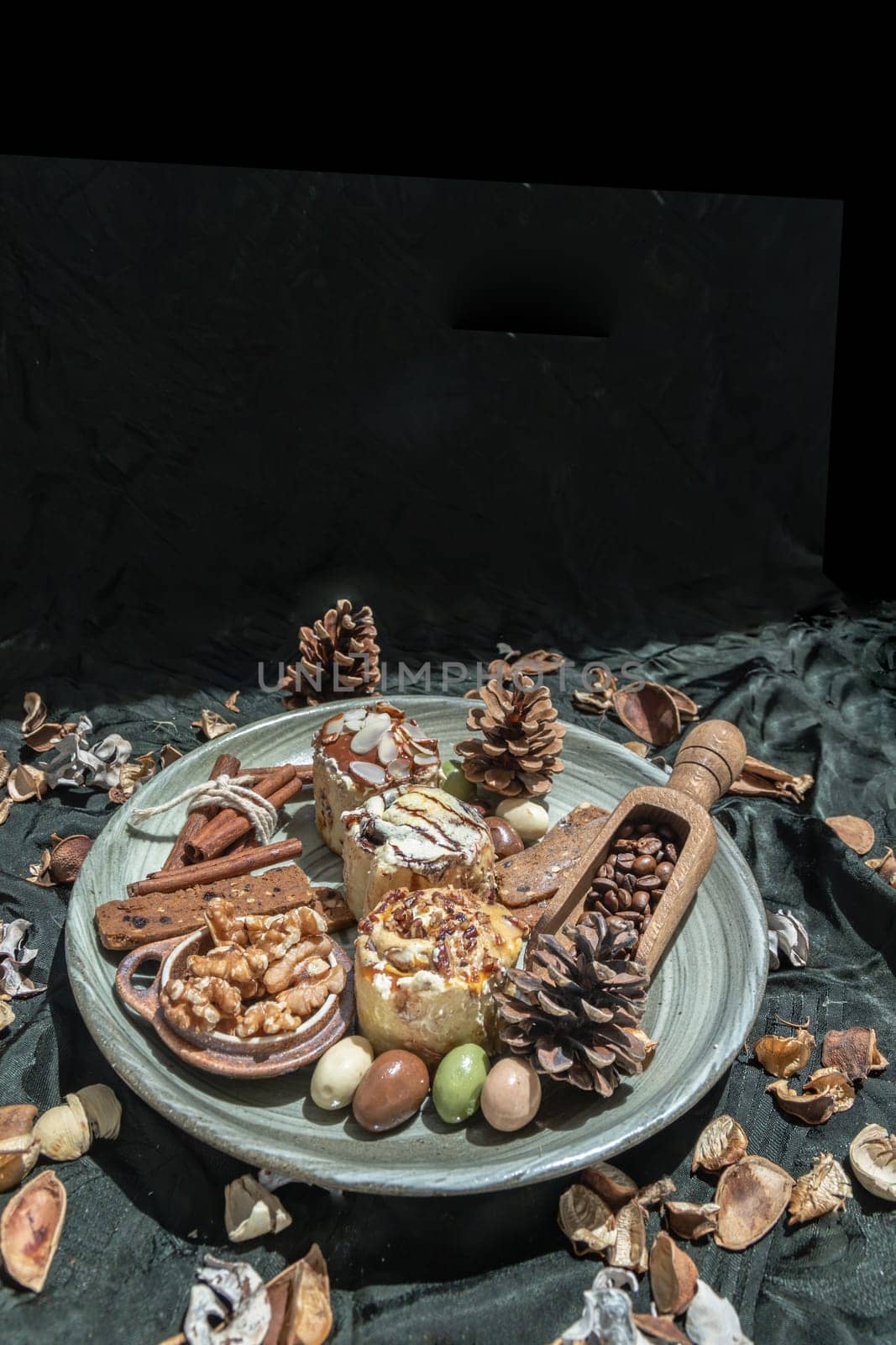 Easter bakery, Stick cookies, Walnuts and Colored eggs with Pine cones on Ceramic plate with Dark background. Space for text, Selective focus.