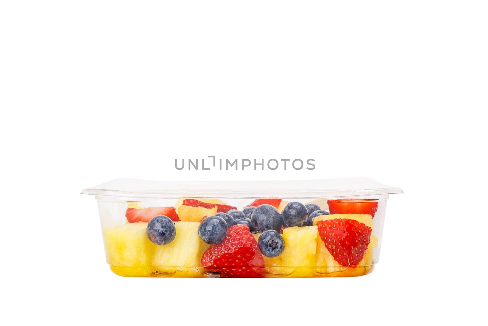Fruit salad with pineapple, strawberries and blueberries in a plastic container on a white background. High quality photo