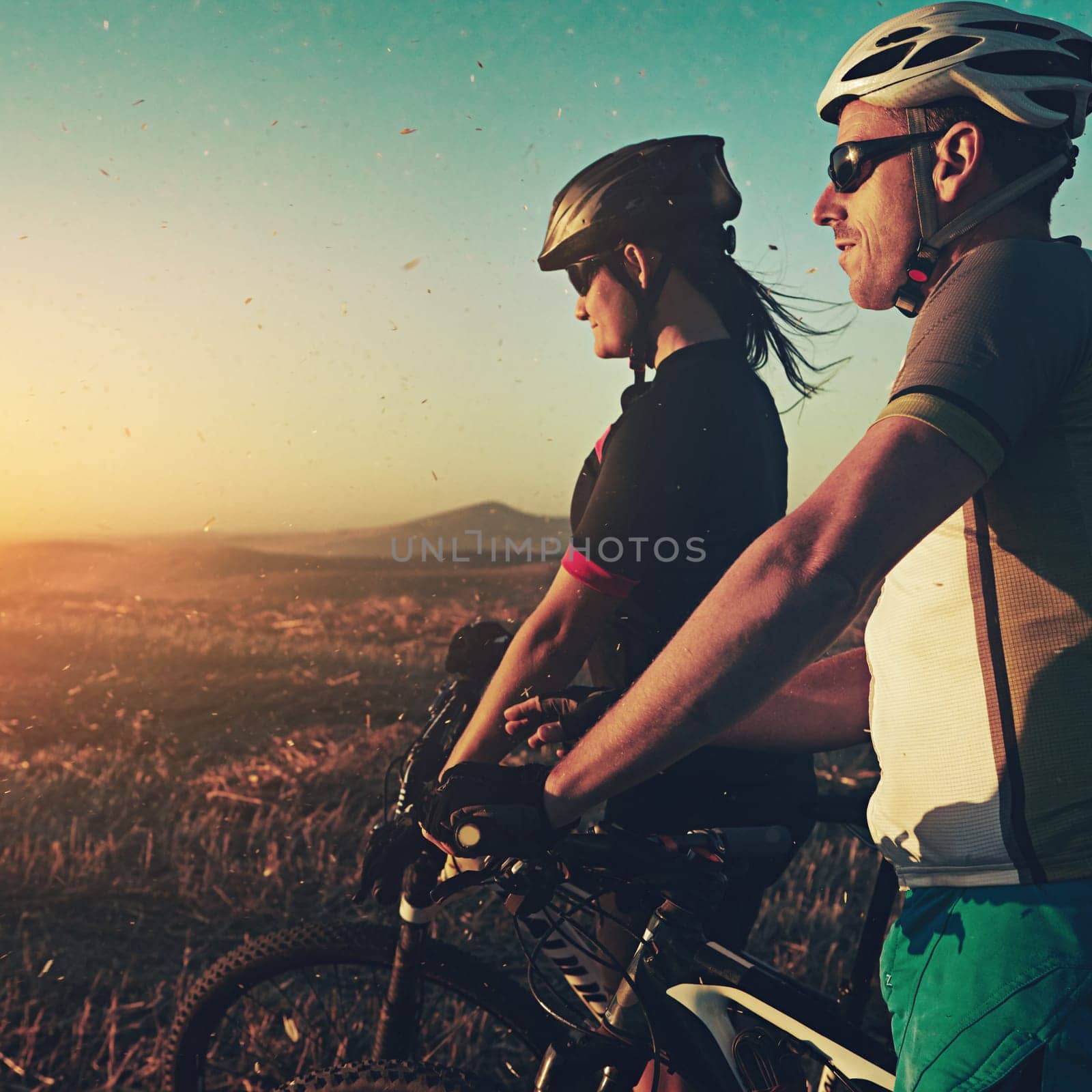 Enjoy every moment of the ride. a pair of adventurous mountain bikers out on a trail on a sunny day. by YuriArcurs