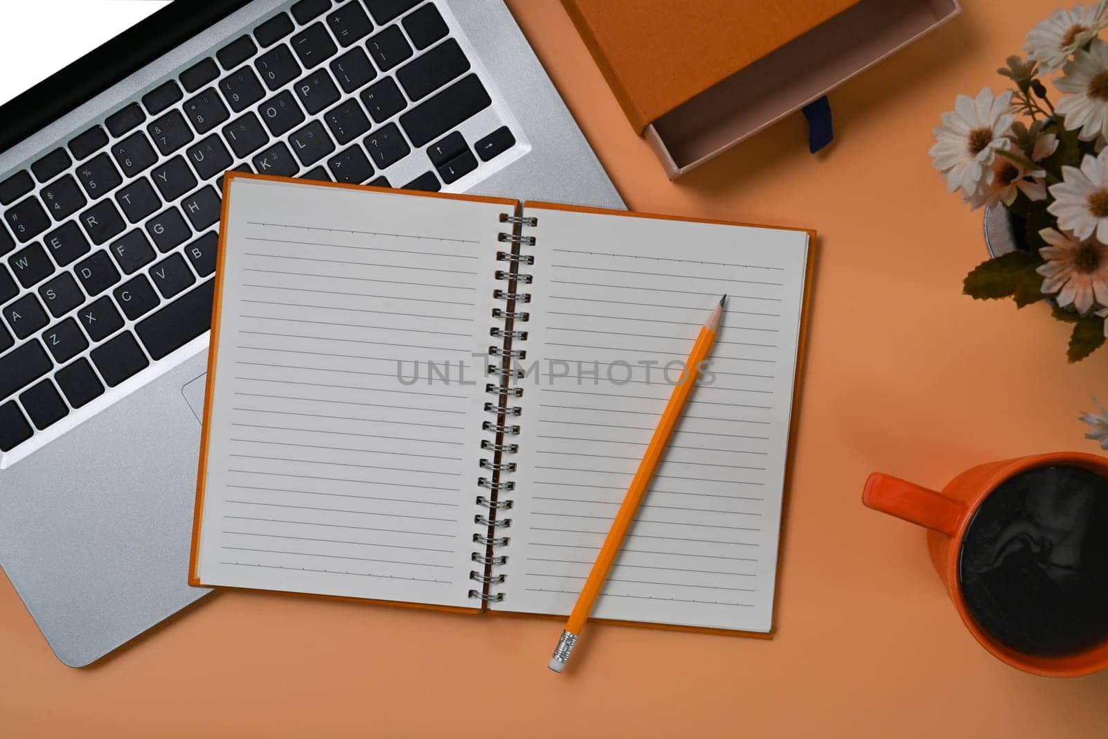 Empty notebook, computer laptop and coffee cup on beige background.