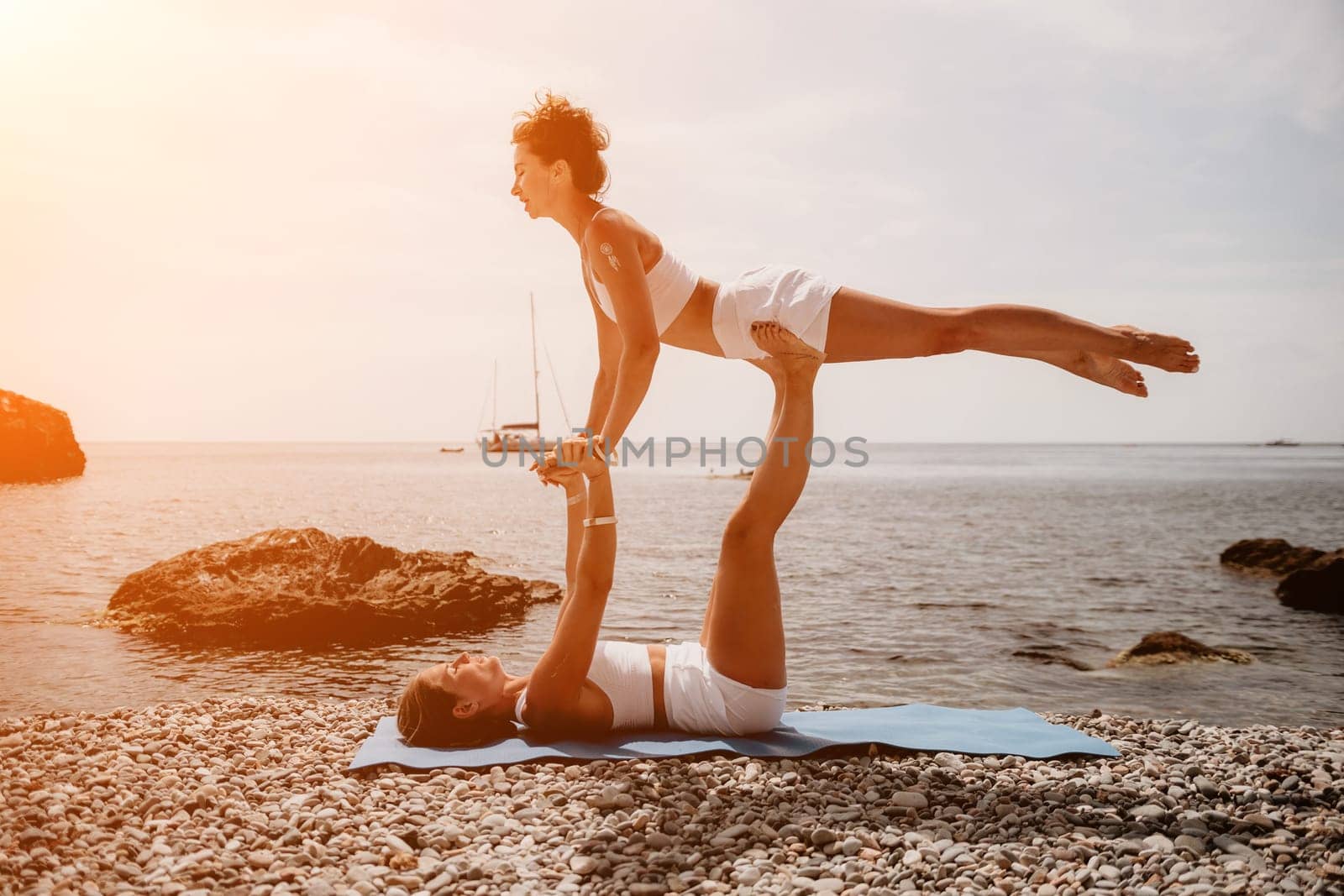 Woman sea yoga. Back view of free calm happy satisfied woman with long hair standing on top rock with yoga position against of sky by the sea. Healthy lifestyle outdoors in nature, fitness concept.