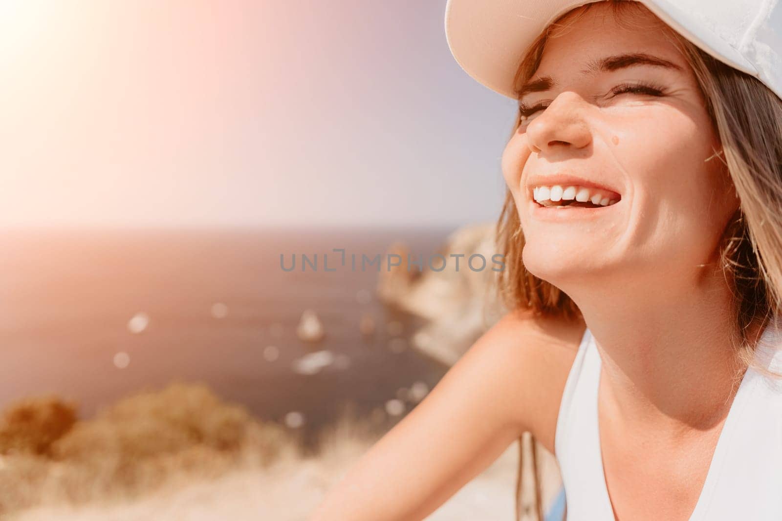 Woman travel sea. Young Happy woman in a long red dress posing on a beach near the sea on background of volcanic rocks, like in Iceland, sharing travel adventure journey