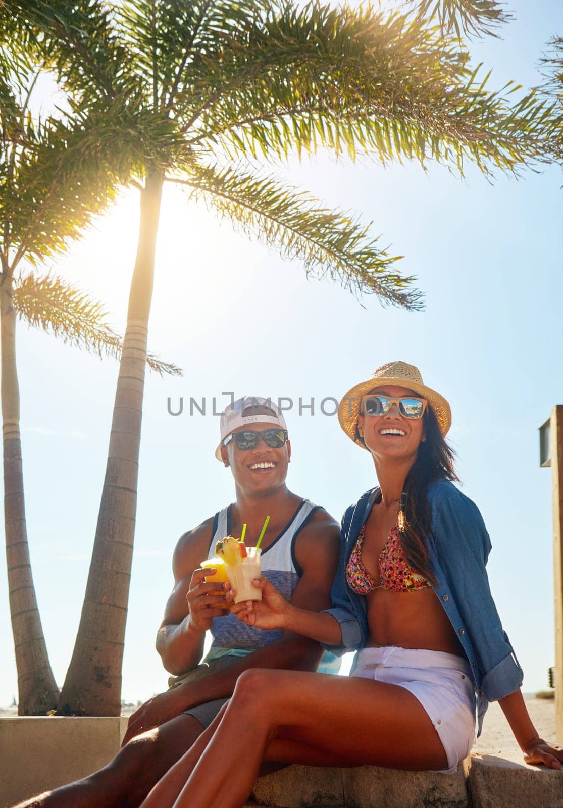 Spending a day in the sun. an affectionate young couple spending a summers day outdoors. by YuriArcurs