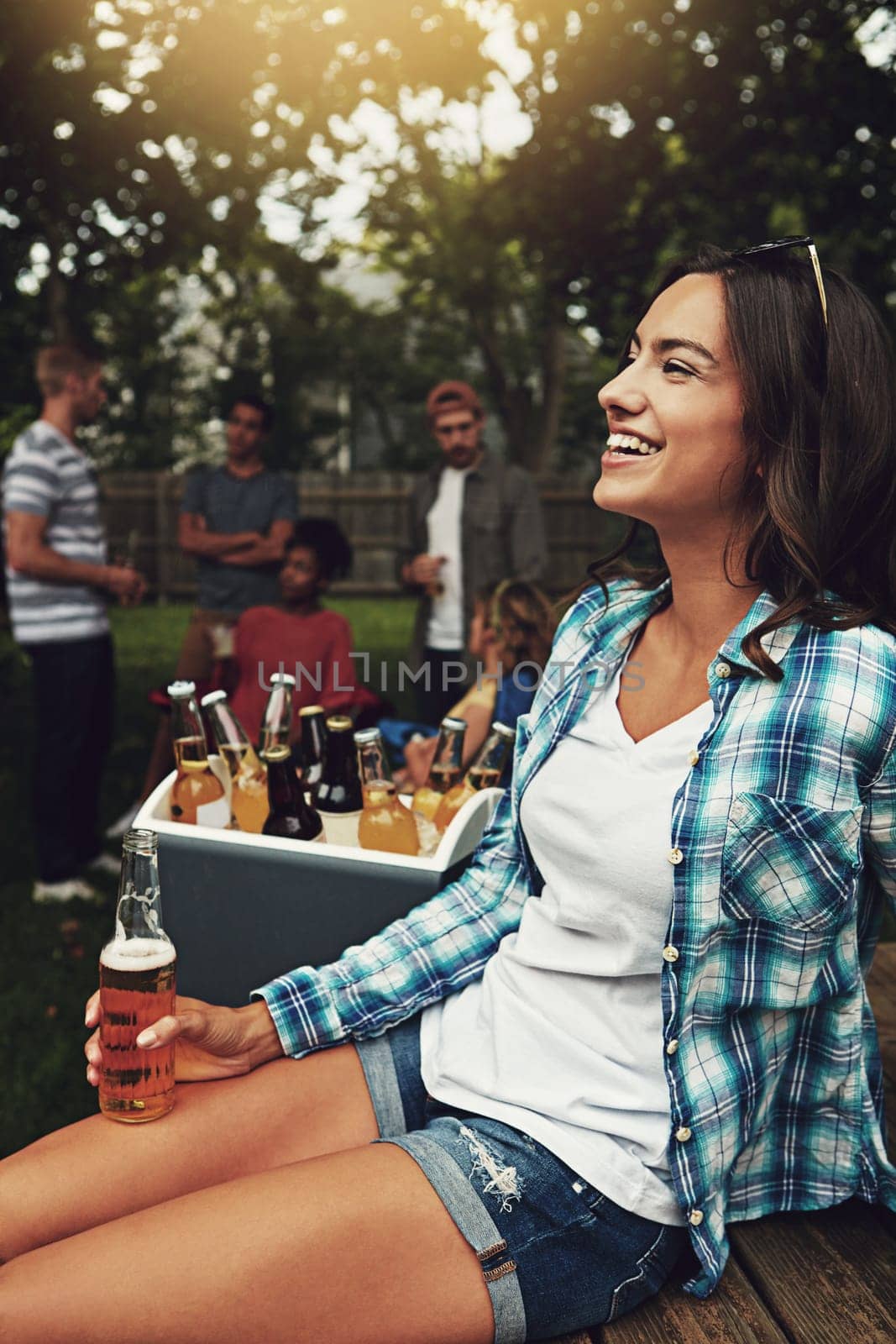 Lets get stuck in weekend mode. a young woman enjoying a party with friends outdoors. by YuriArcurs
