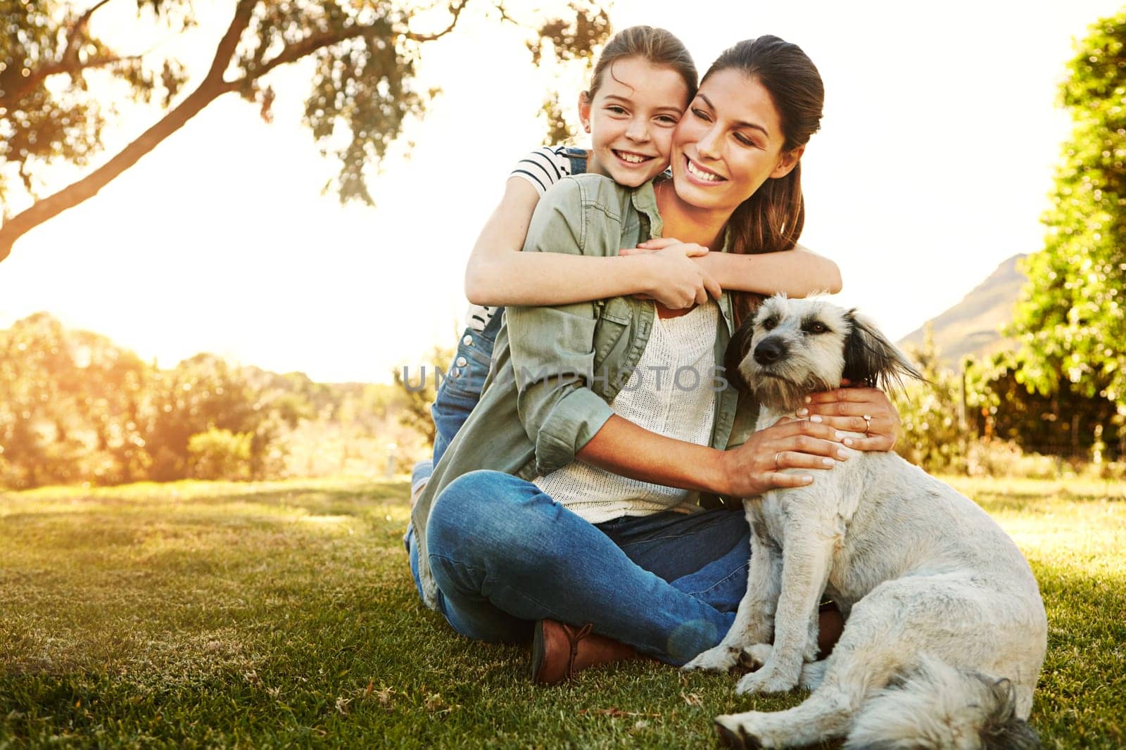 The best fun in the sun happens at the park. a mother and her daughter playing with their dog at the park. by YuriArcurs